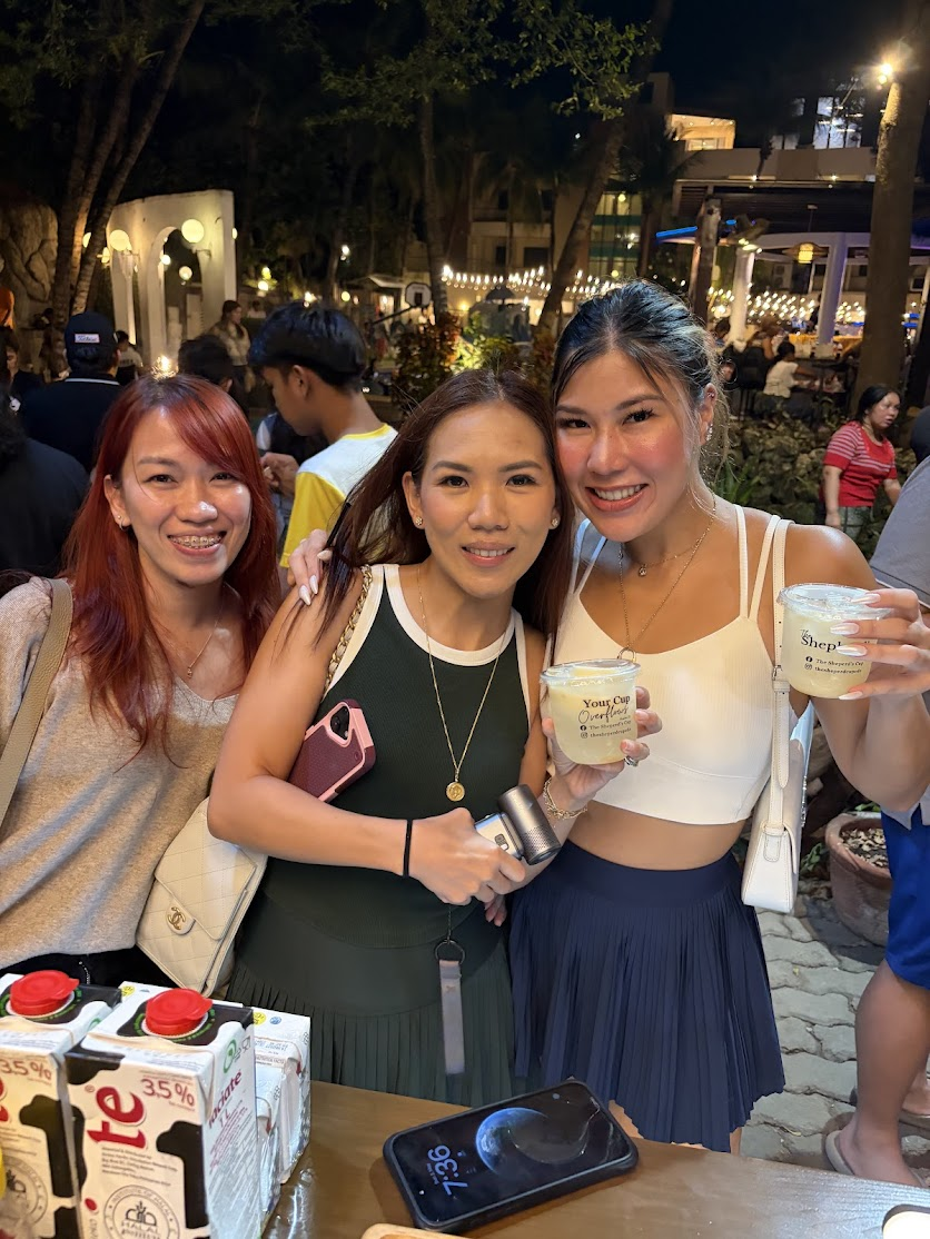 Three friends holding 'Your Cup Overflows' branded drinks from The Shepherd's Cup